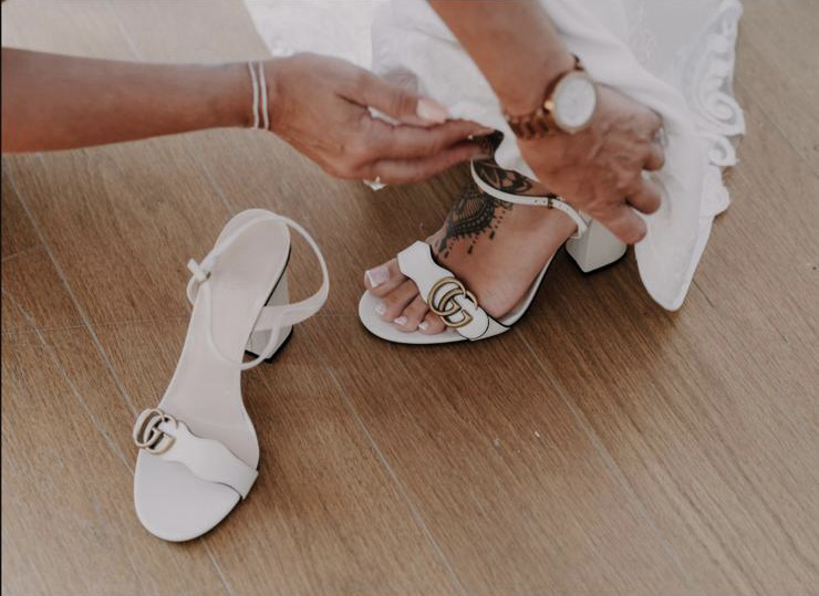 White block-heel sandals with gold detail during bridal preparations